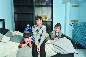 Menashe, Yehuda and Sruli Goldstein of Oak Park relax in one of the renovated bedrooms in their family’s basement, which had been badly damaged by flood waters. Photo Credit: Aaron Geler 